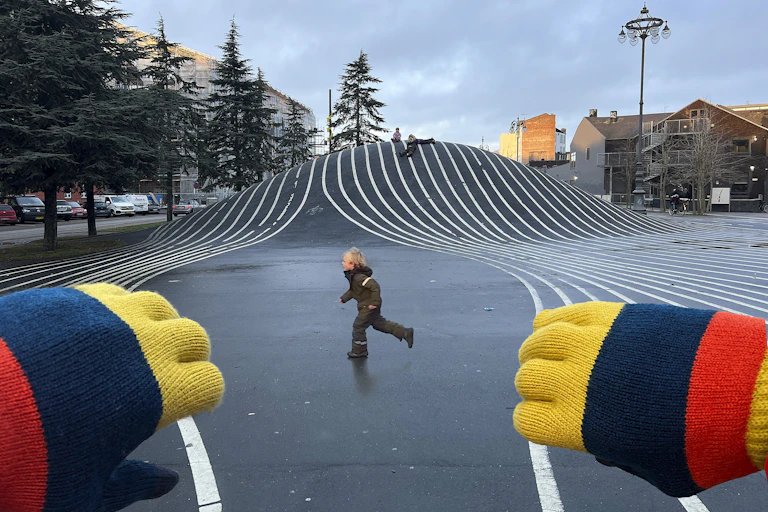 Une illusion d’optique créée avec des mains au premier plan donnant l’impression qu’elles écartent des lignes situées à l’arrière-plan.