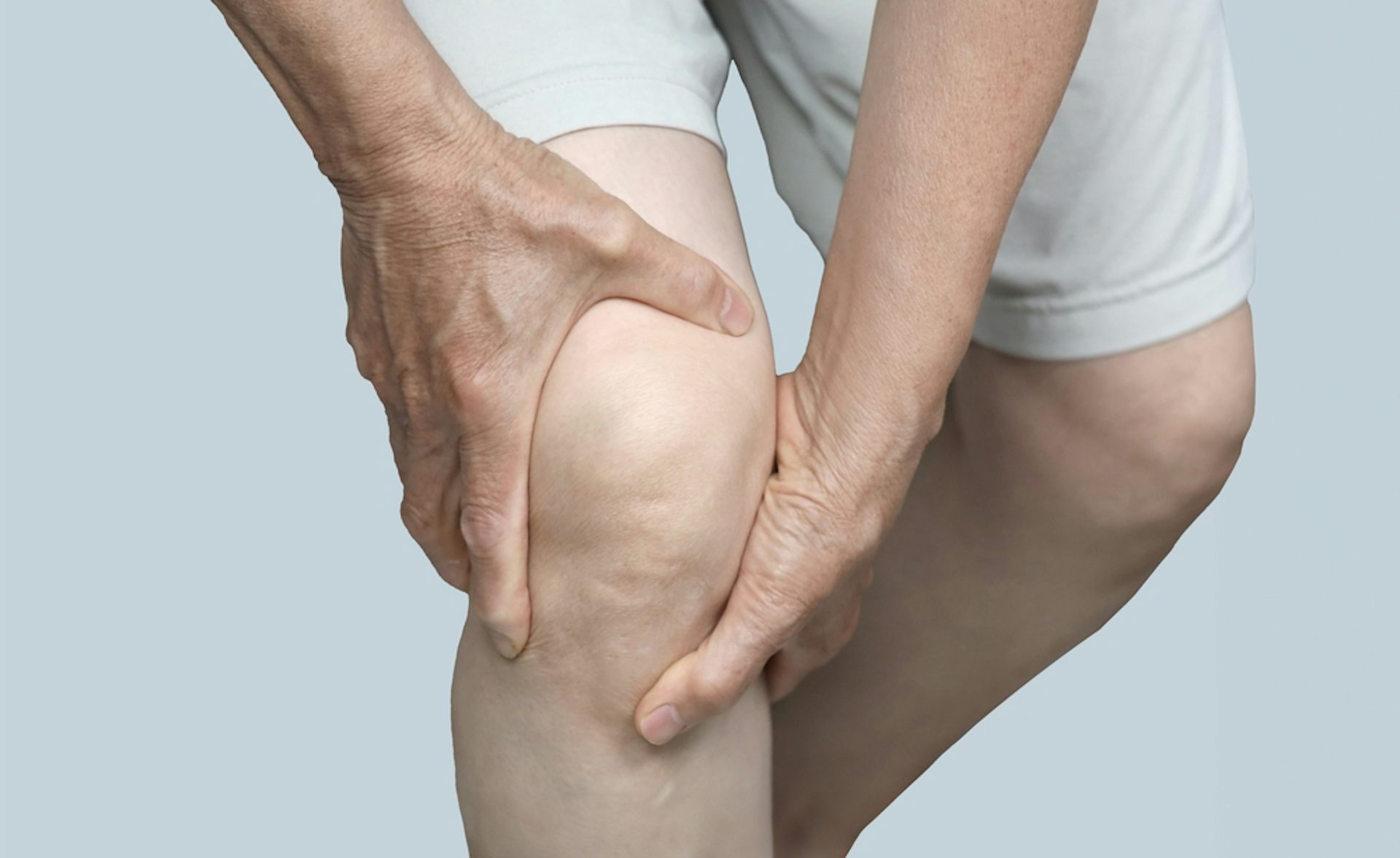 A man holding his knee in agony.