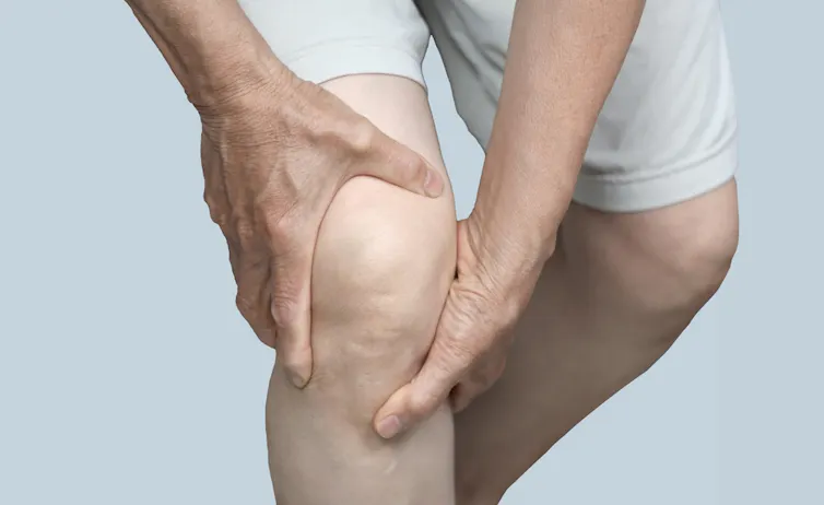 A man holding his knee in agony.