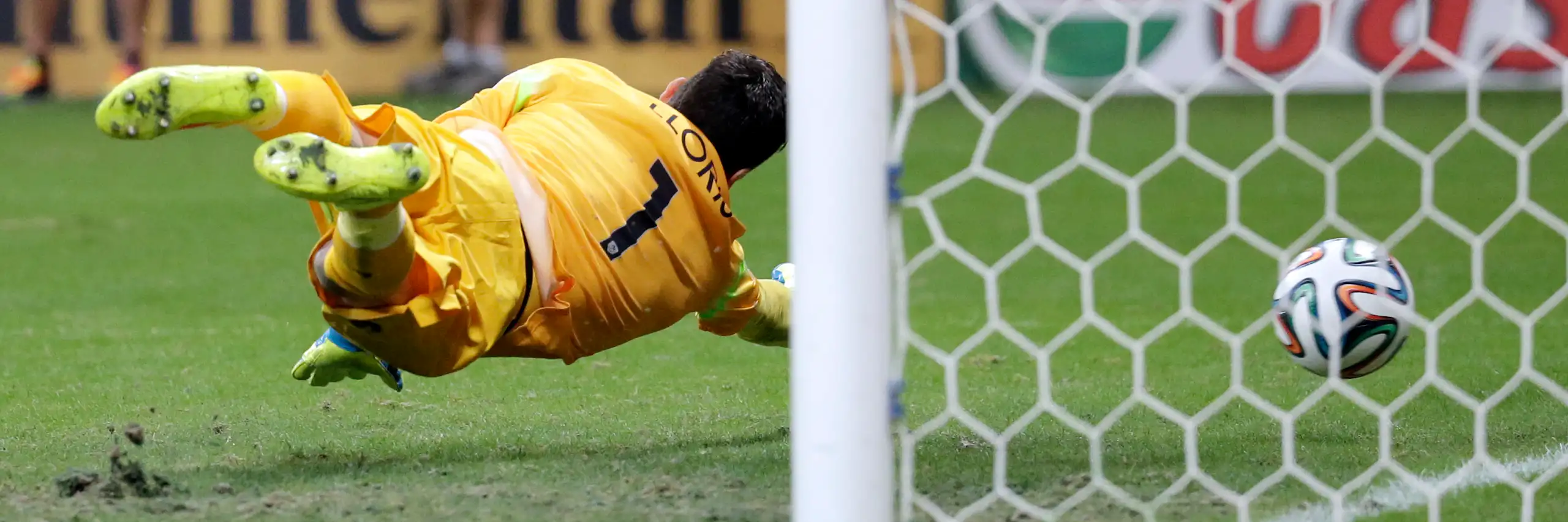 Kiper Prancis, Hugo Lloris, berusaha menyelamatkan gawangnya dengan melompat tetapi tidak mampu menghentikan gol dari tendangan bebas Blerim Dzemaili dari Swiss selama pertandingan sepak bola Piala Dunia antara Swiss dan Prancis pada tahun 2014.