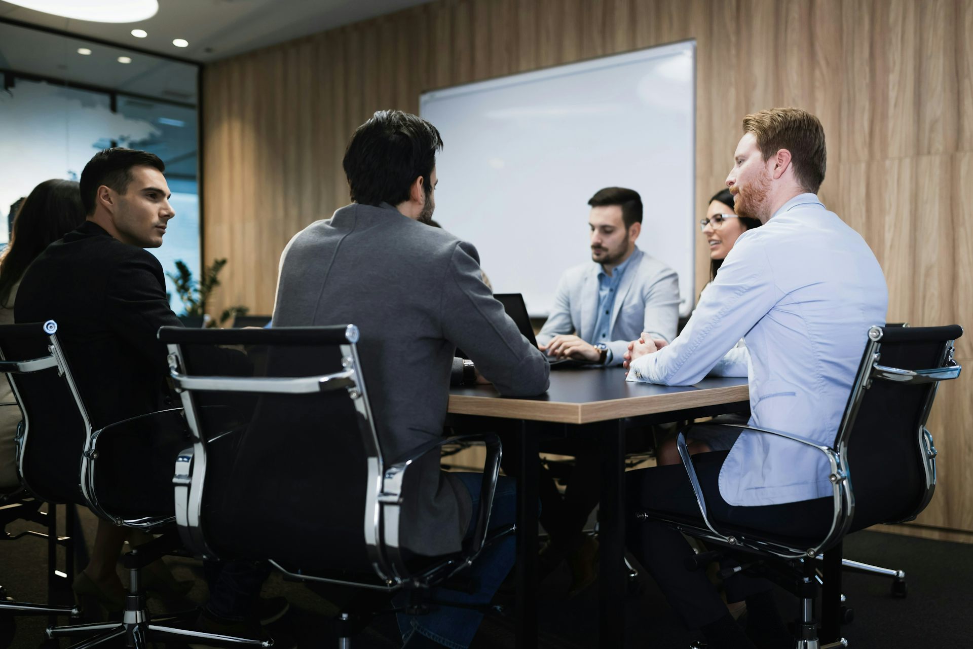 A group of people, nearly all men, sitting at a conference table
