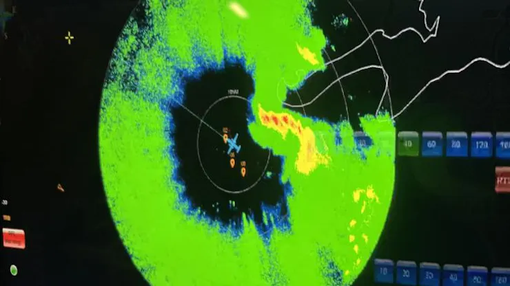 A radar screen with an airplane in the center of a storm circulation.