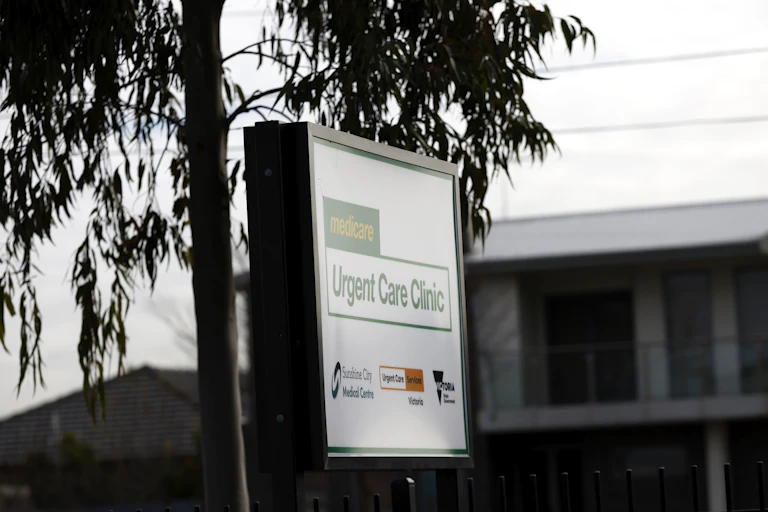 A Medicare Urgent Care Clinic sign is shaded by a gumtree