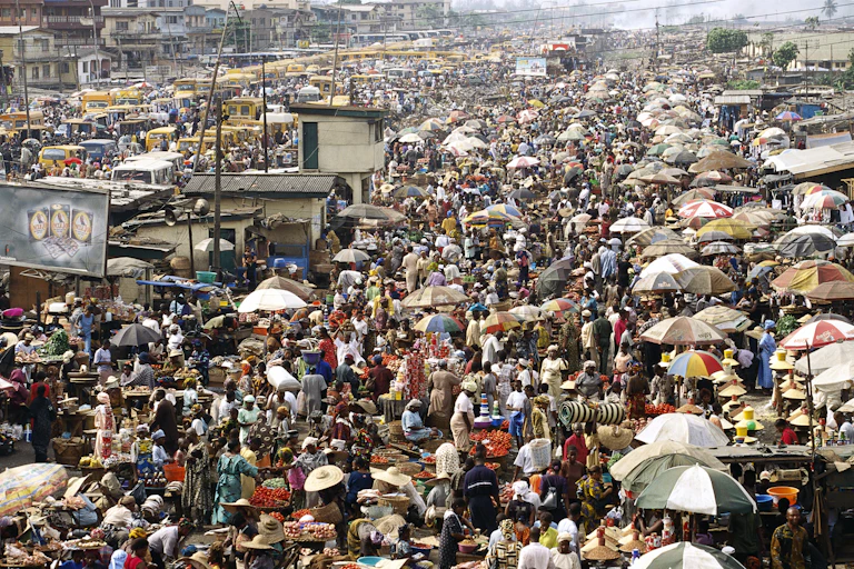 A very busy open air marketplace with hundreds of stalls and customers