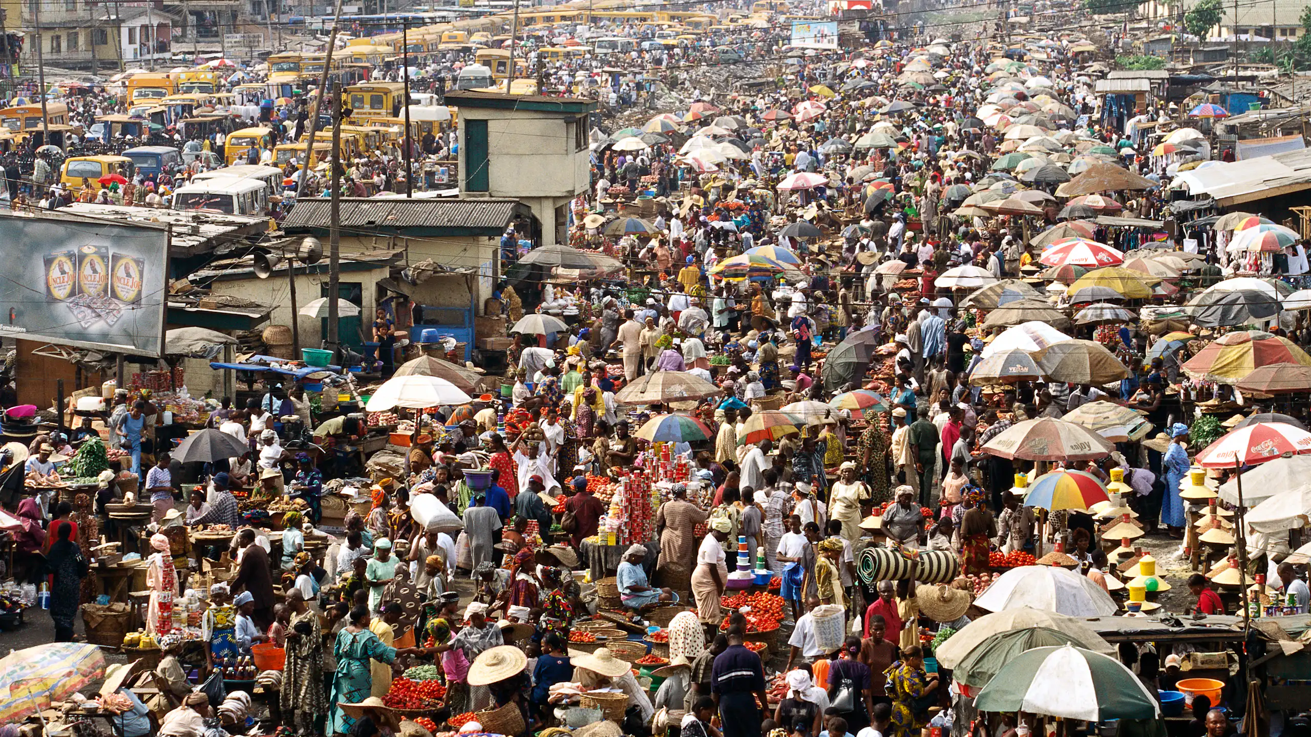 A very busy open air marketplace with hundreds of stalls and customers