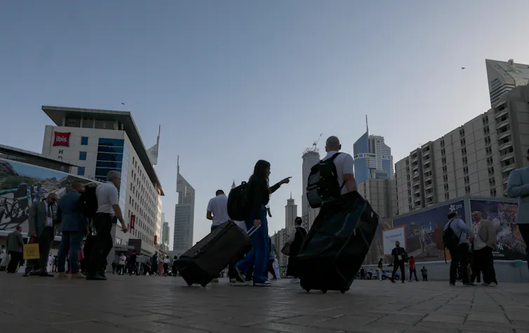 Tourists carrying their luggage through Dubai.