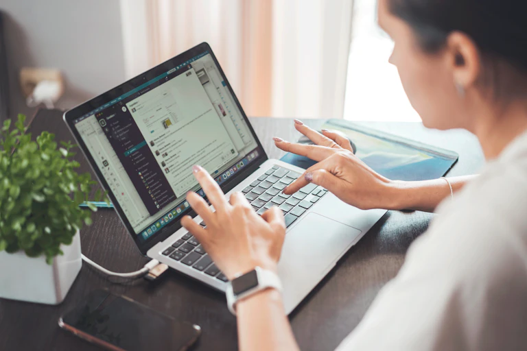 Une jeune femme travaille sur son ordinateur portable.