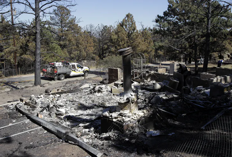 La Constitución y las leyes de Estados Unidos no protegen a las empresas petroleras de ser demandadas por dañar el clima. 1 Un camión de bomberos pasa junto a una casa quemada.