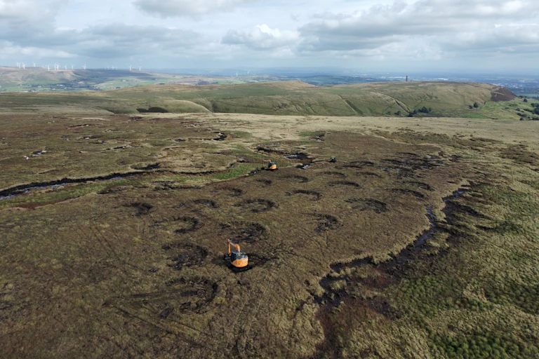 Excavators cut shallow areas in the peatlands as part of a project to develop more wetlands.