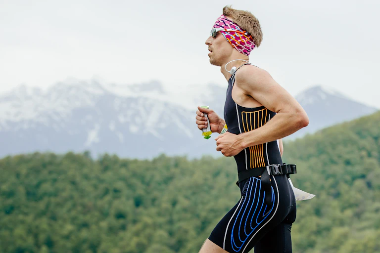 A man running a long-distance race holds an energy gel in his hand.