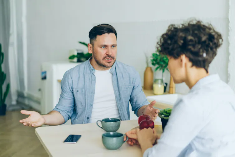 Un homme frustré discute avec une femme dans leur salle à manger