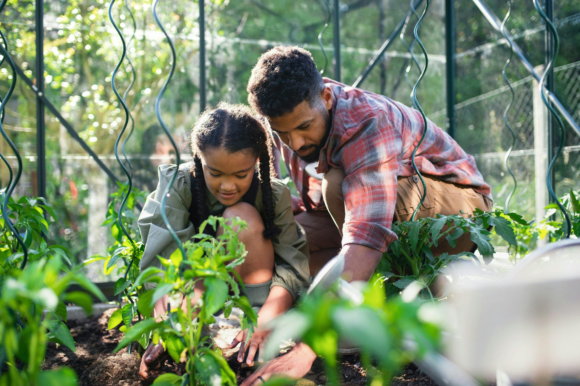 Un hombre y una adolescente juntos en el jardín.
