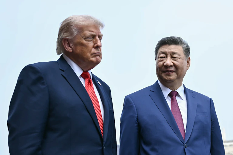 Two men in suits stand.