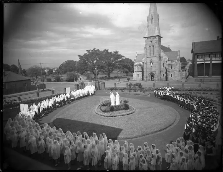 Black and white photograph: many girls walk in a circle.