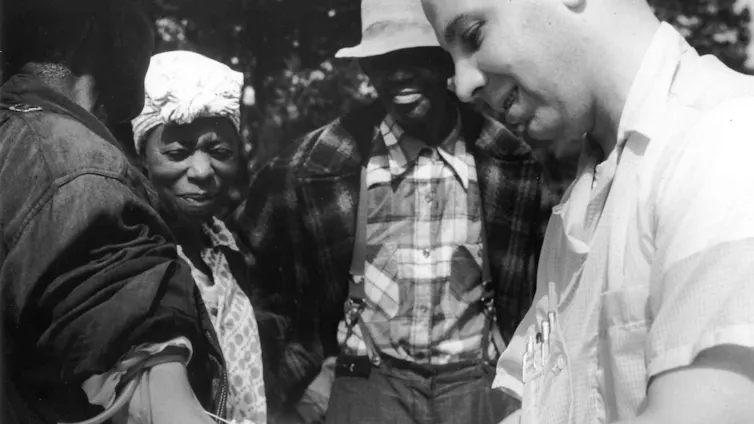 Fotografía en blanco y negro en la que se ve a un médico extraer sangre de un paciente como parte del estudio de la sífilis de Tuskegee.