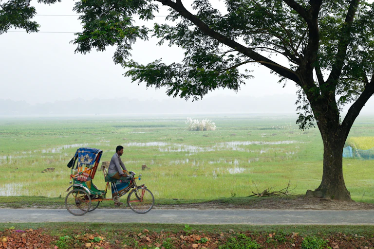 person cycling on bike in rural bangladesh