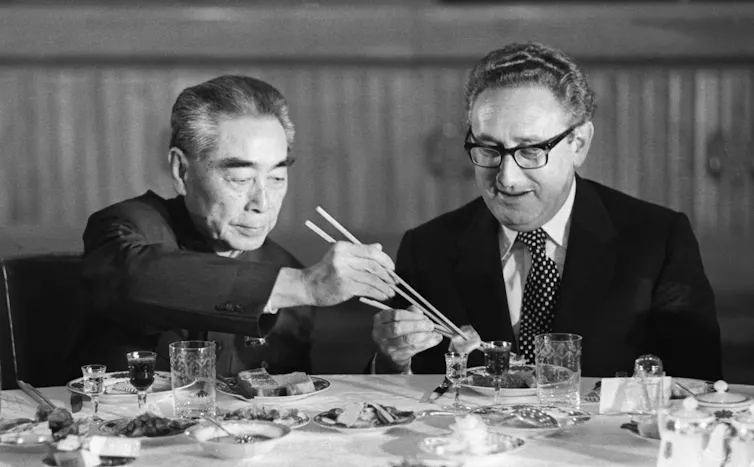 De las costillas de res al paseo 'celestial': el simbolismo de la cumbre Xi-Trump subraya el poder de Estados Unidos y la tradición china 1 Un hombre usa palillos para transferir comida al plato de otro hombre.