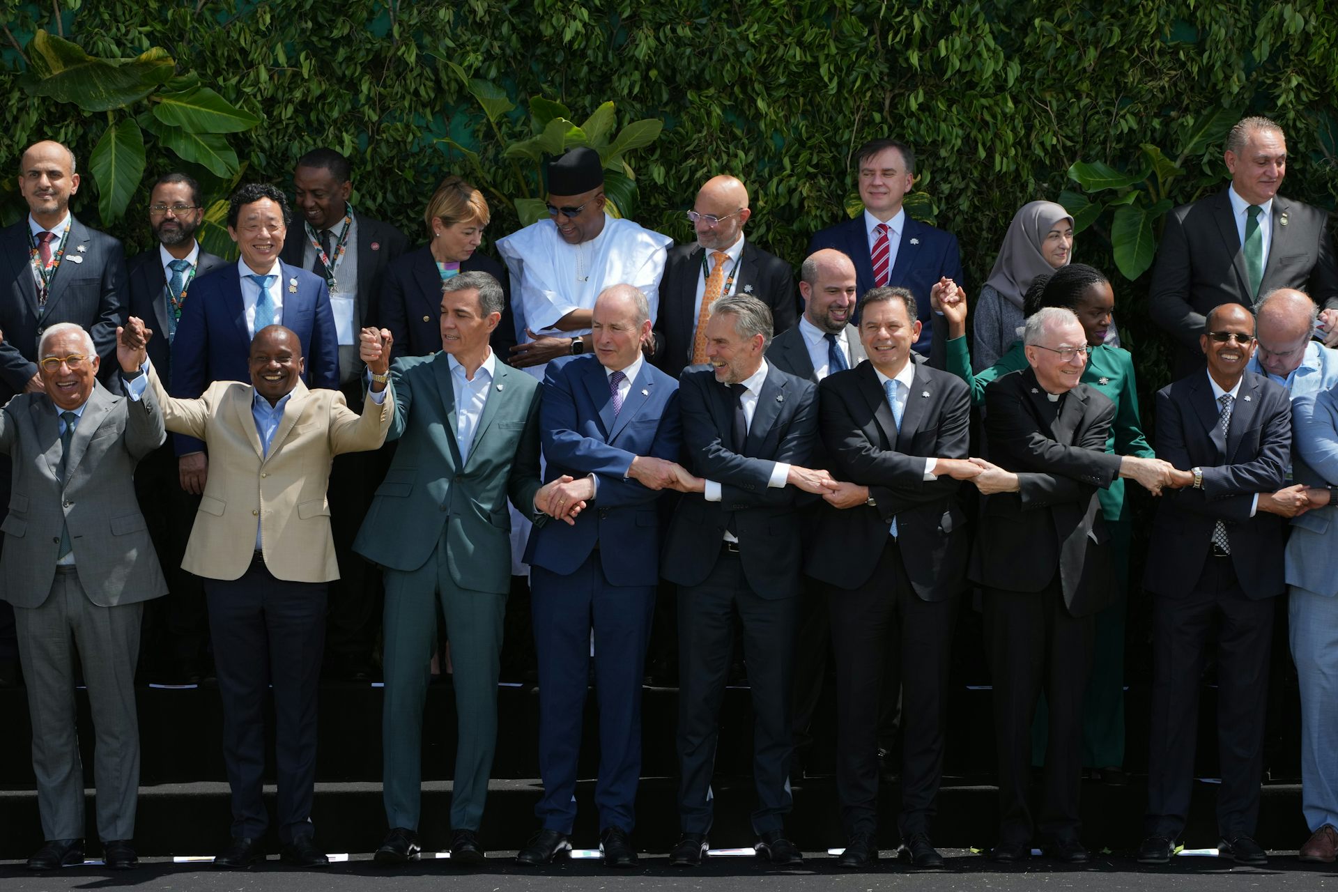 Global leaders attending the U.N. Climate Summit pose for a group photo and hold hands.