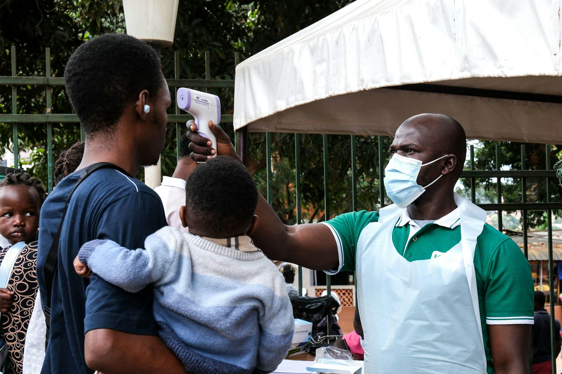 A health official uses a thermometer to screen people in front of Kibuli Muslim Hospital in Kampala, Uganda, May 16 2026.