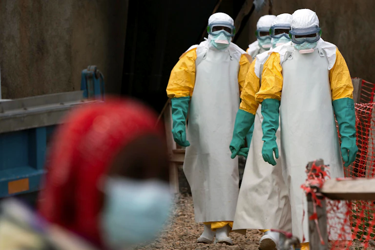 Health workers dress in protective gear to treat patients with Ebola