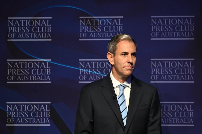 Jim Chalmers, on the right of the frame, stands in the National Press Club of Australia.