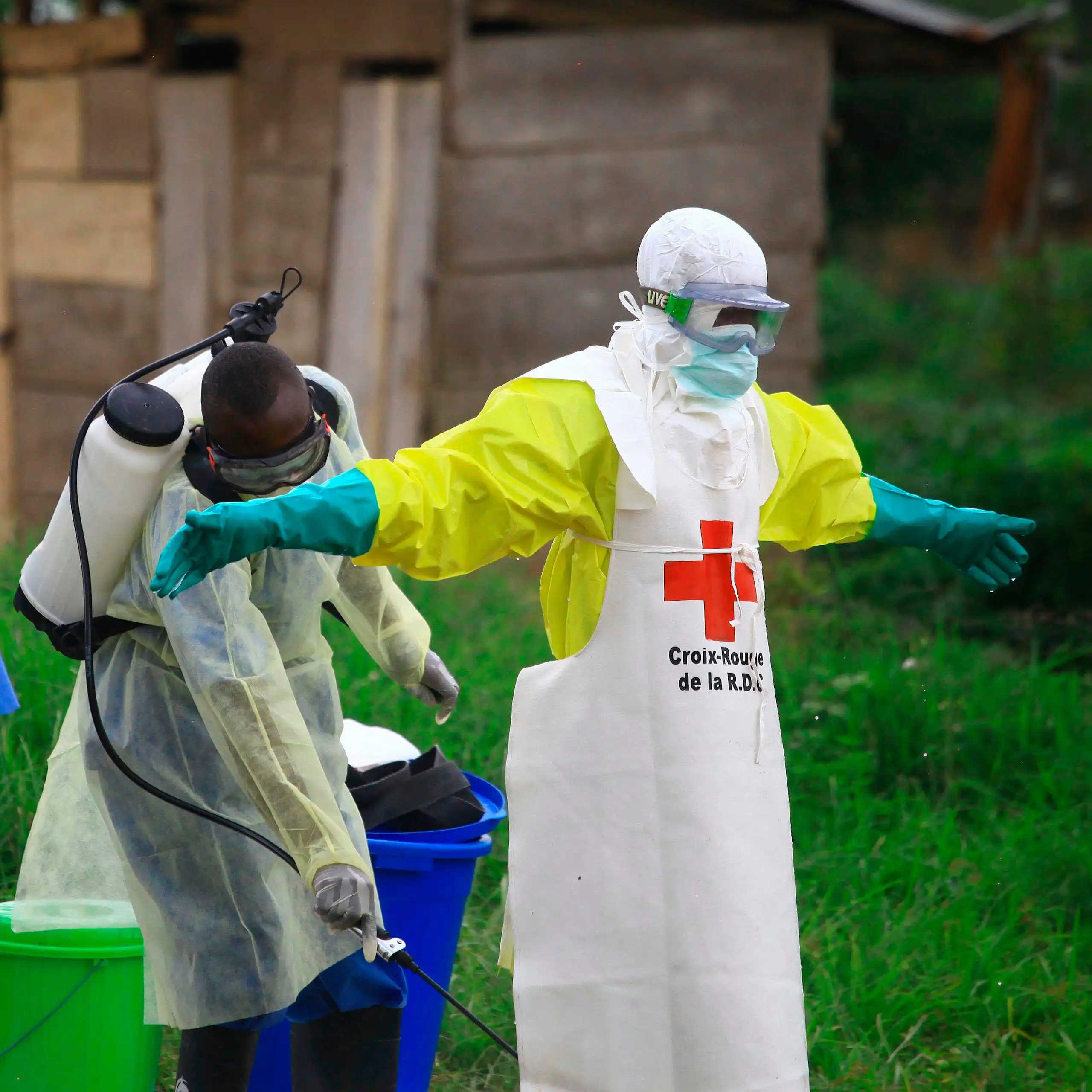A health worker sprays disinfectant on his colleague after working at an Ebola treatment center in Beni, eastern Congo, Sept 9, 2018.