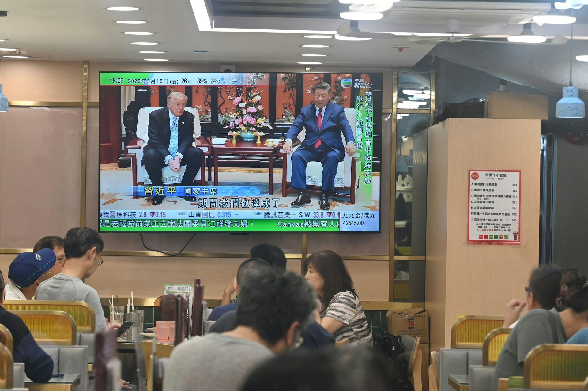 A large TV screen shows the summit meetings between US president, Donald Trump, and Chinese president, Xi Jinping.