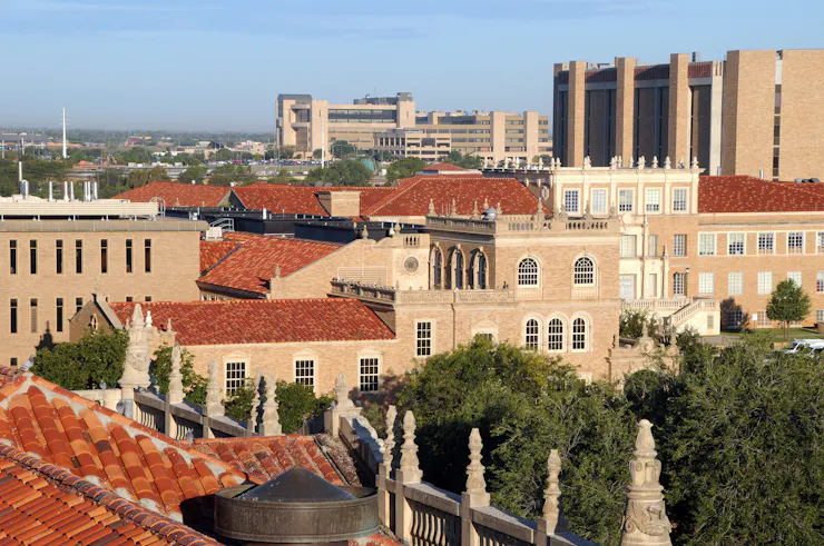 A series of brown buildings are seen grouped closely together from above.
