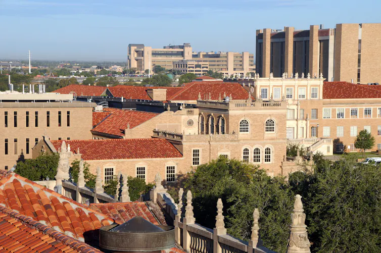 A series of brown buildings are seen grouped closely together from above.