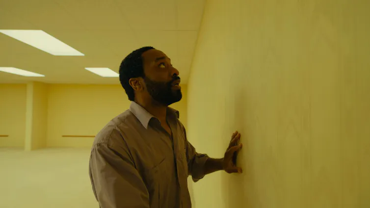 Chiwetel Ejiofor touching a yellow wall