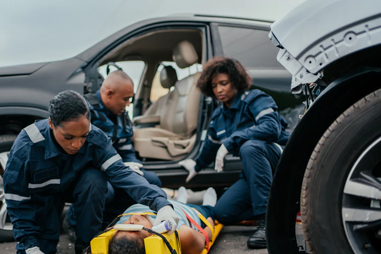 Paramedics assist a car accident victim.
