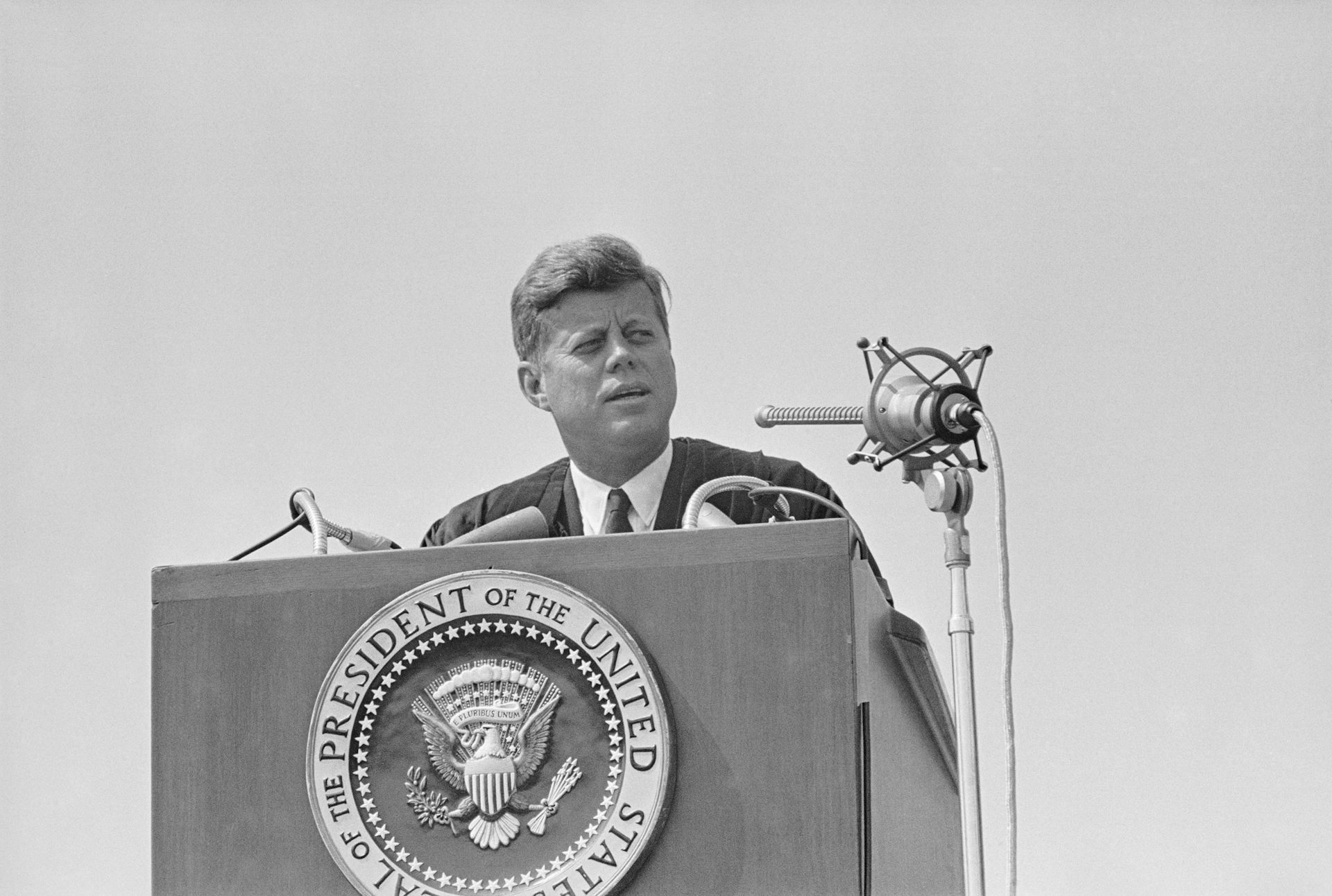 A man stands at a podium that says 'president of the United States' in a black-and-white photo.