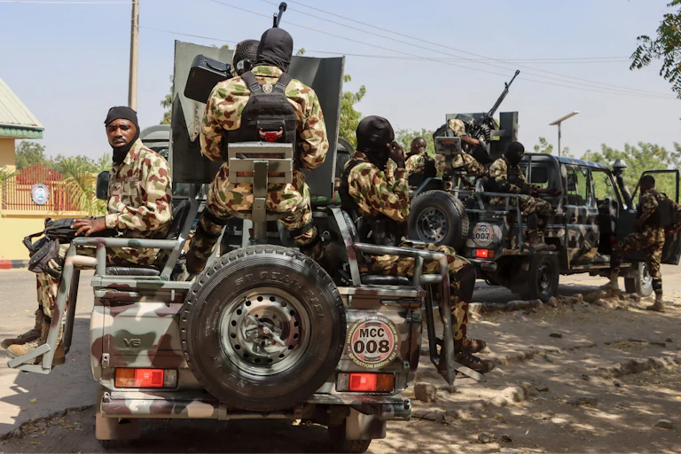 People in camouflage uniform, with weapons, on military vehicles