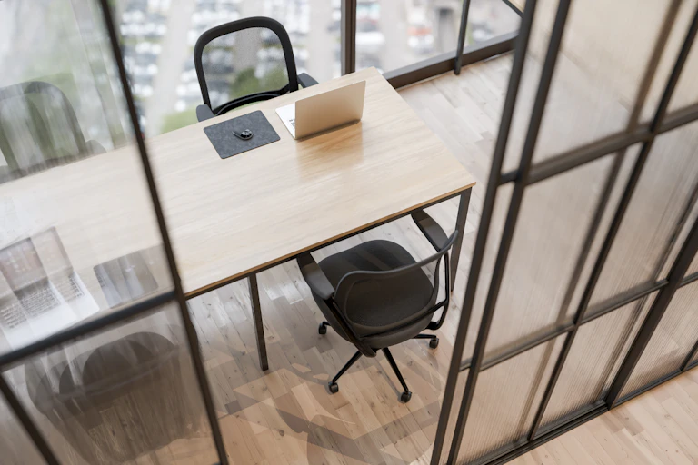 Empty workspace with a table and two chairs next to a window.
