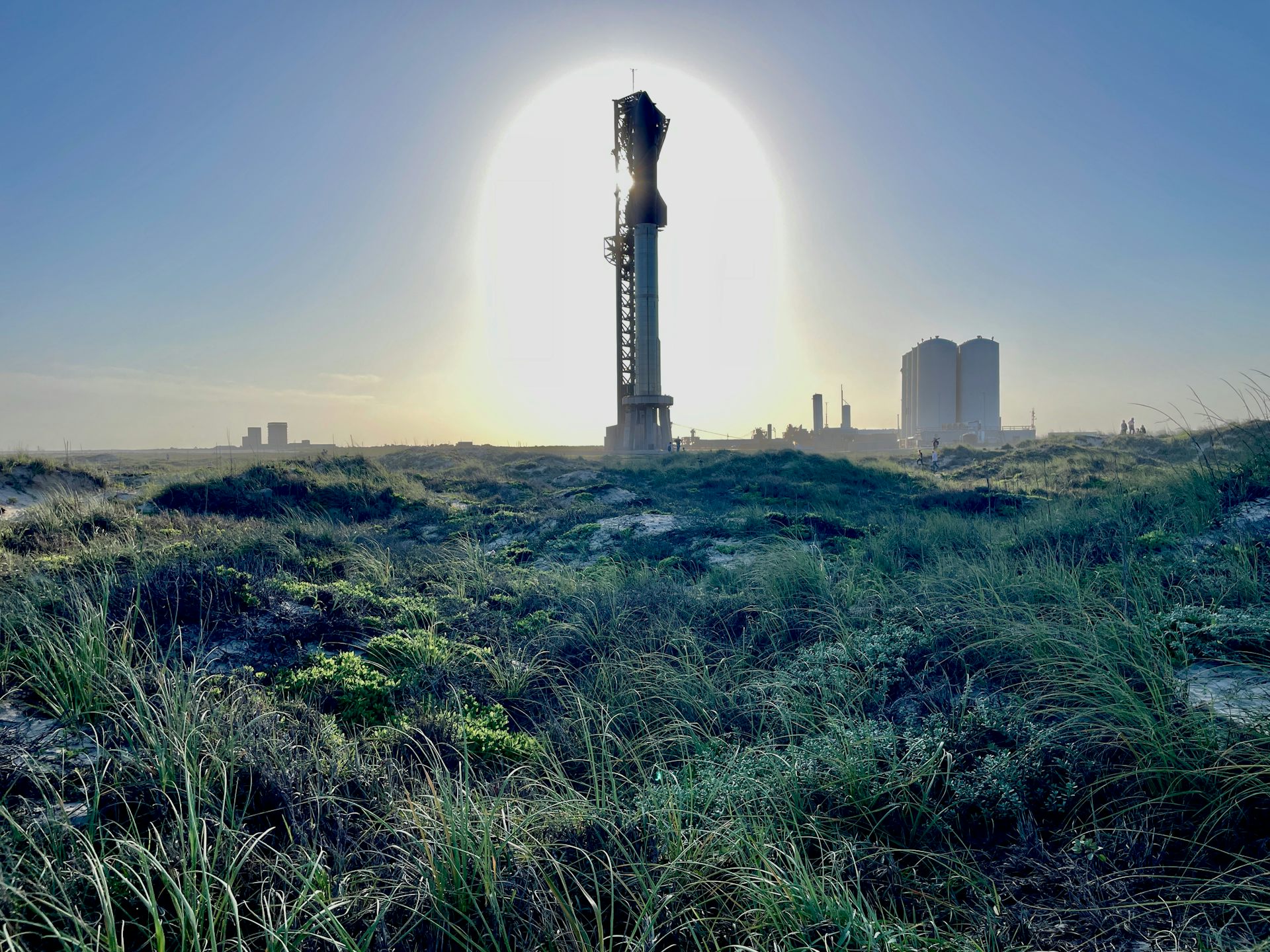 A large rocket sits on a launch pad in the midst of a wetland