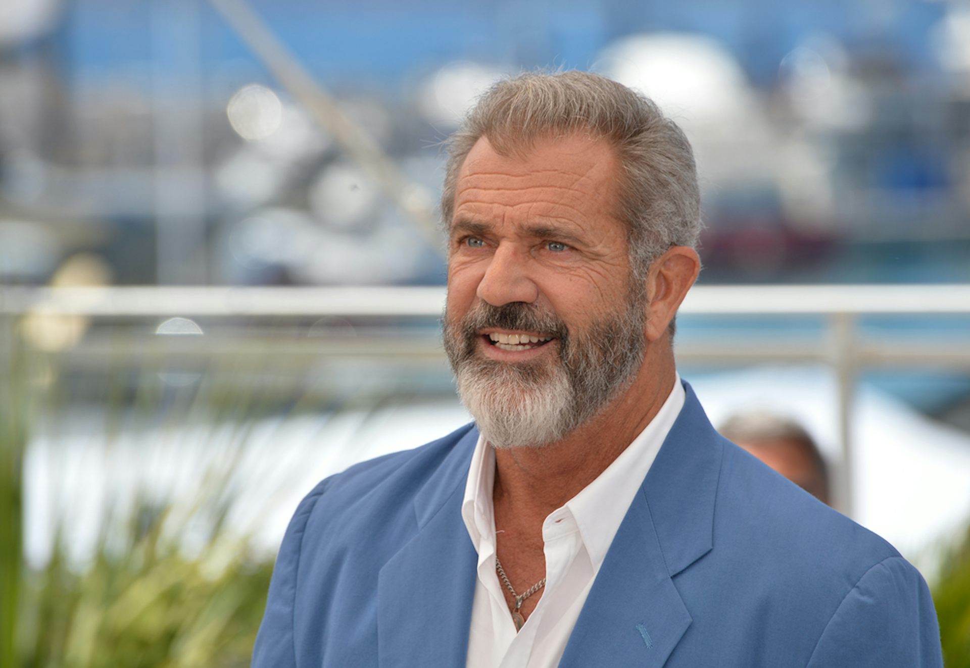 Actor Mel Gibson in a white shirt and blue blazer.