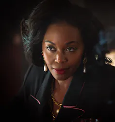 An attractive woman dressed in black, subtly lit.
