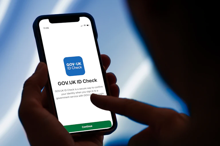 Hand holding phone with GOV.UK ID on screen.
