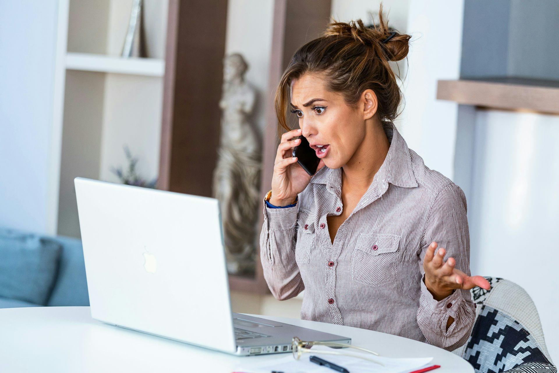 A woman speaking on the phone and gesticulating with her hands in frustration.