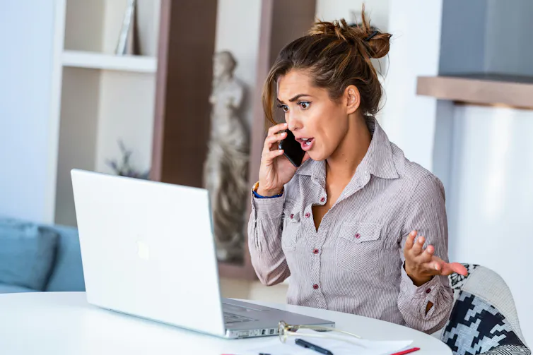 A woman speaking on the phone and gesticulating with her hands in frustration.