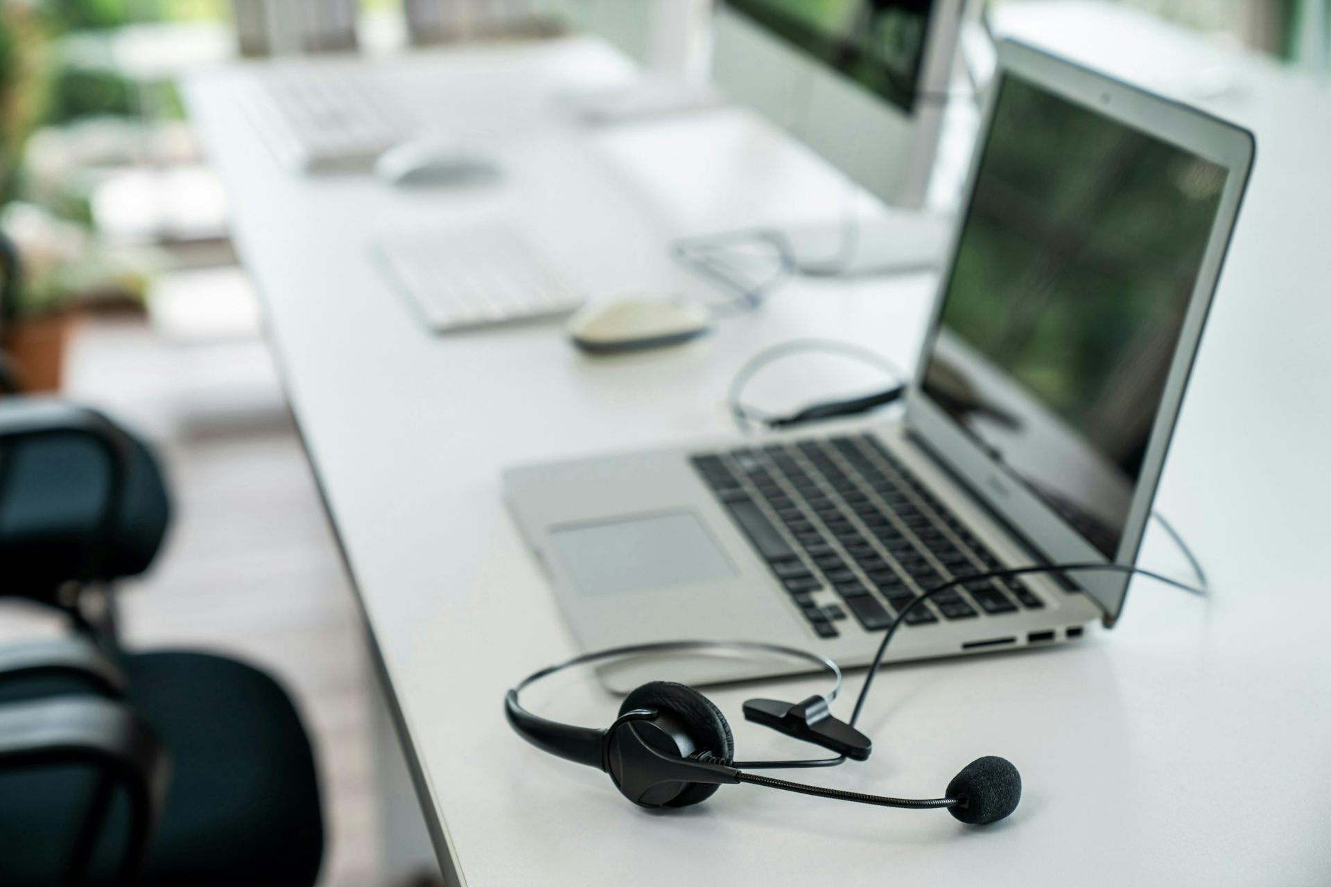 A desk with a computer and a headset.