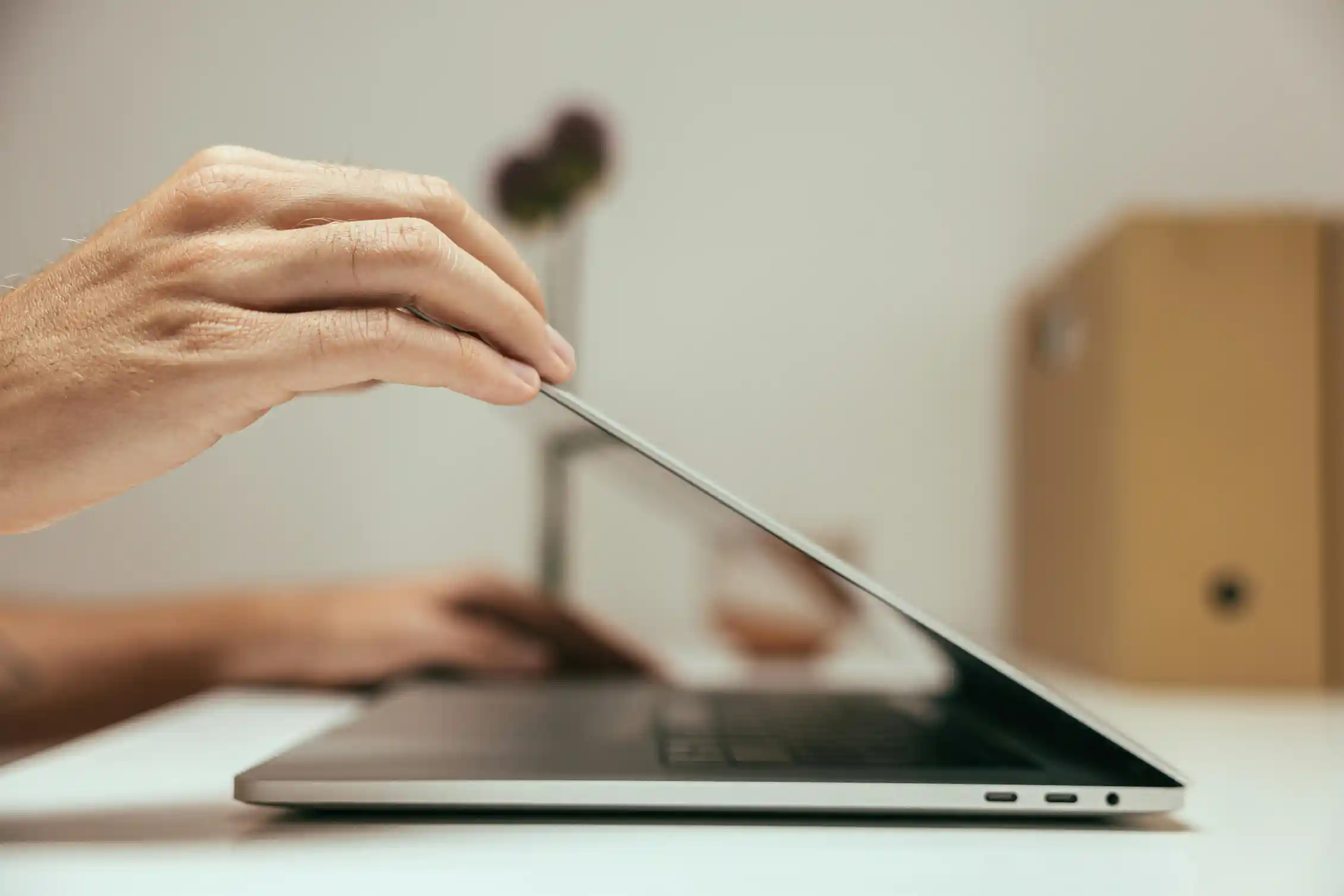 Close up of a person closing a laptop.