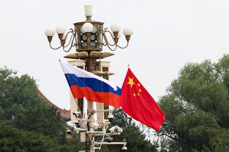 The Russian and Chinese flags flutter at Tiananmen Square in Beijing.