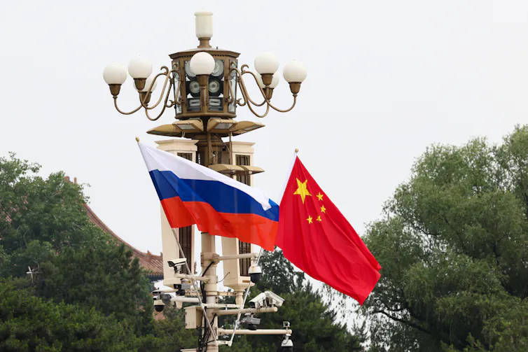 The Russian and Chinese flags flutter at Tiananmen Square in Beijing.