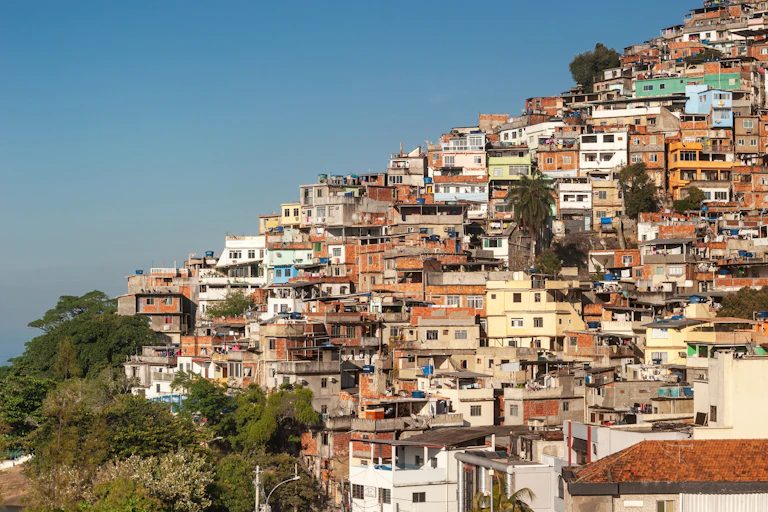 slum homes on hillside without any green spaces, blue sky