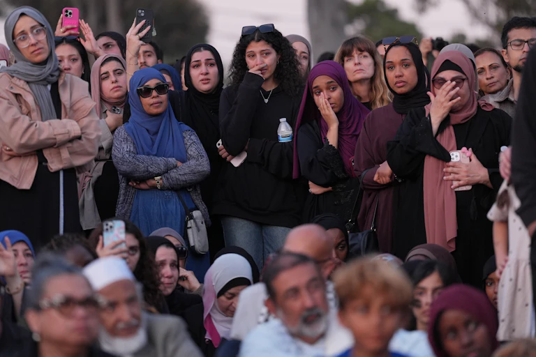 A group of people gathered and mourning at a vigil.