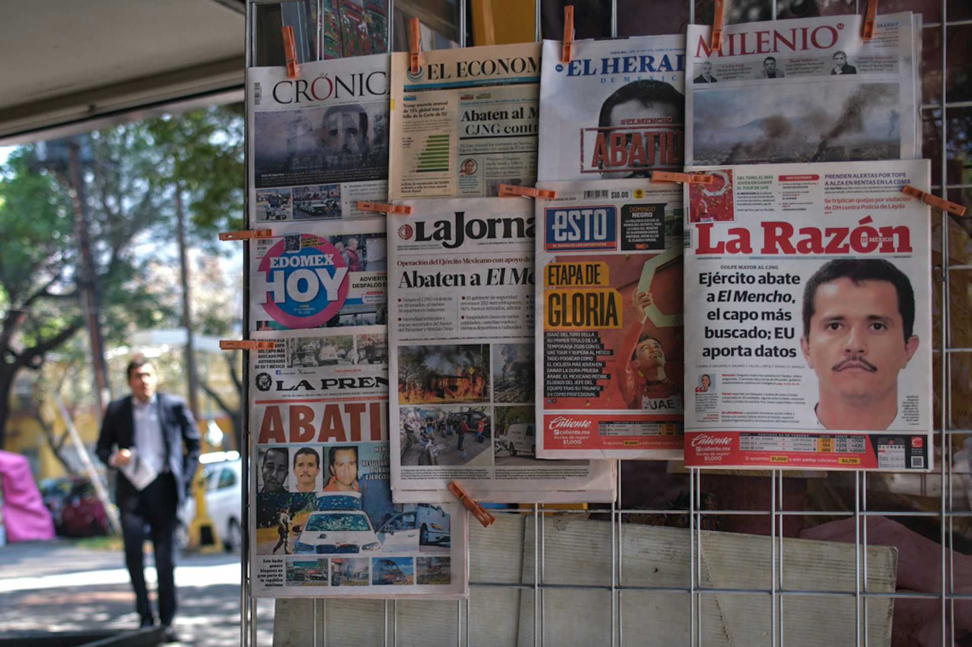 Newspapers hang on display at a kiosk.