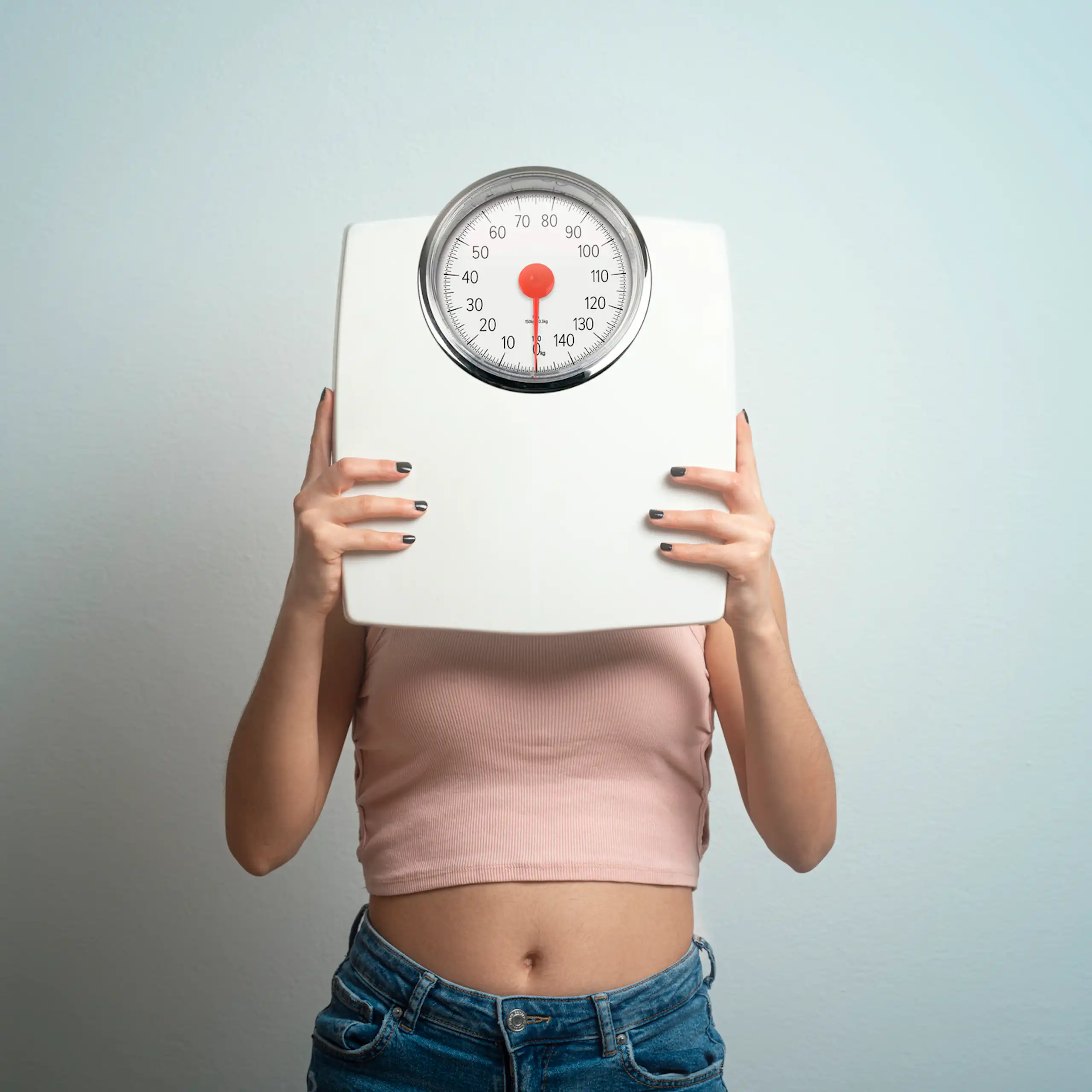 Person holding scale over face