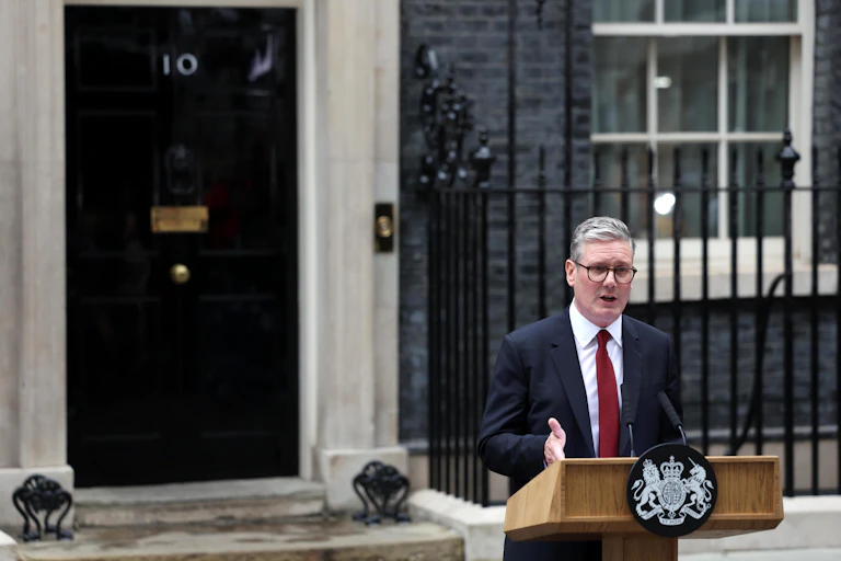 keir starmer at a lectern with the door of number 10 behind him.
