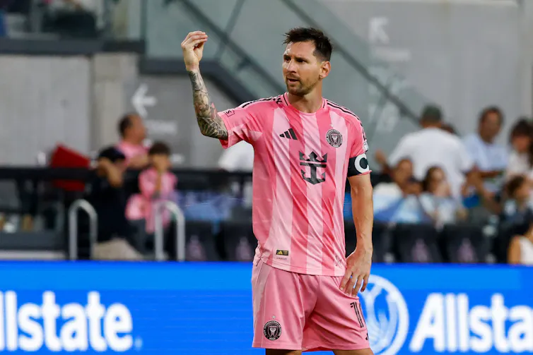 Lionel Messi in an Inter Miami uniform makes the 'money' hand gesture.